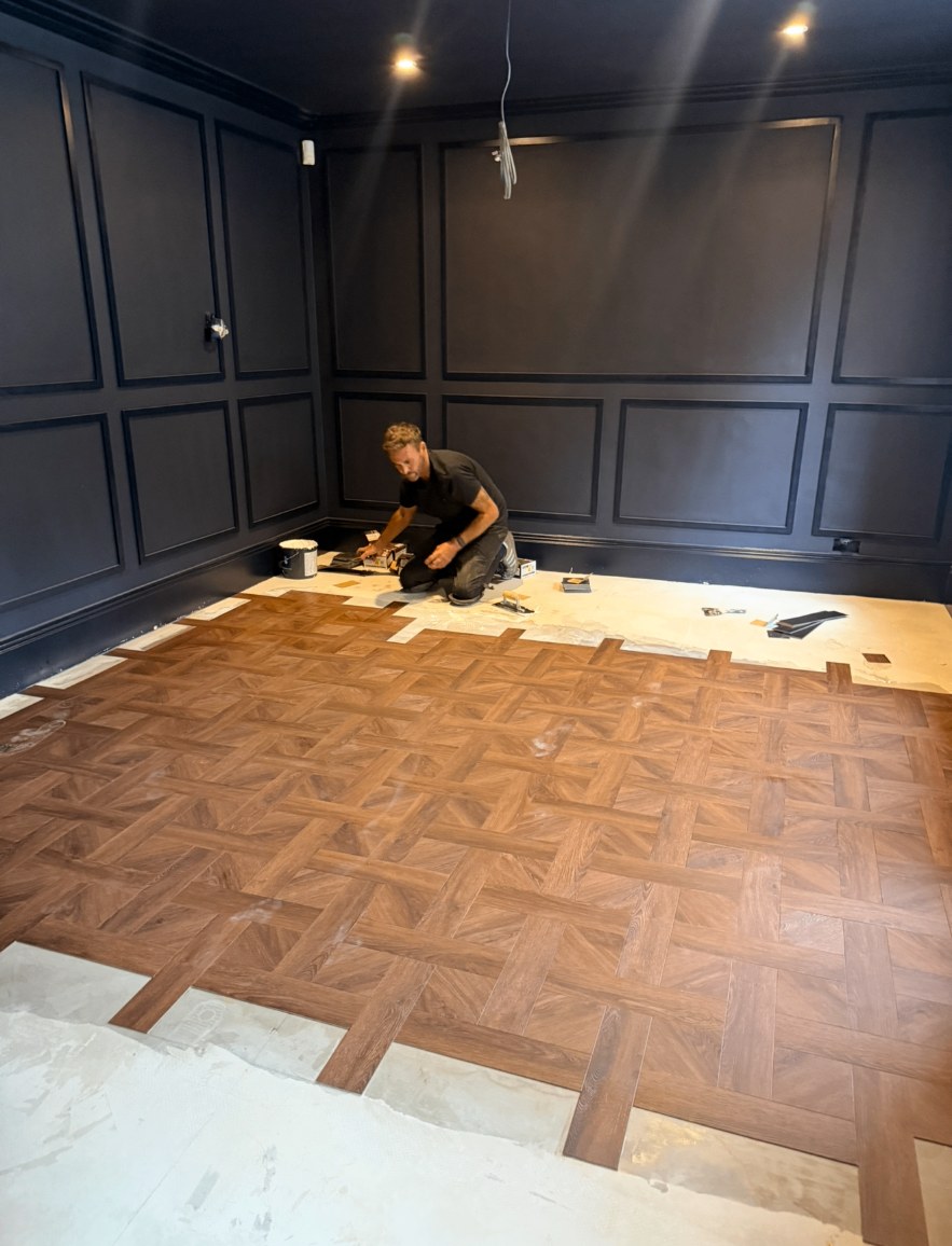 Parquet-style flooring being laid in the navy panelled room