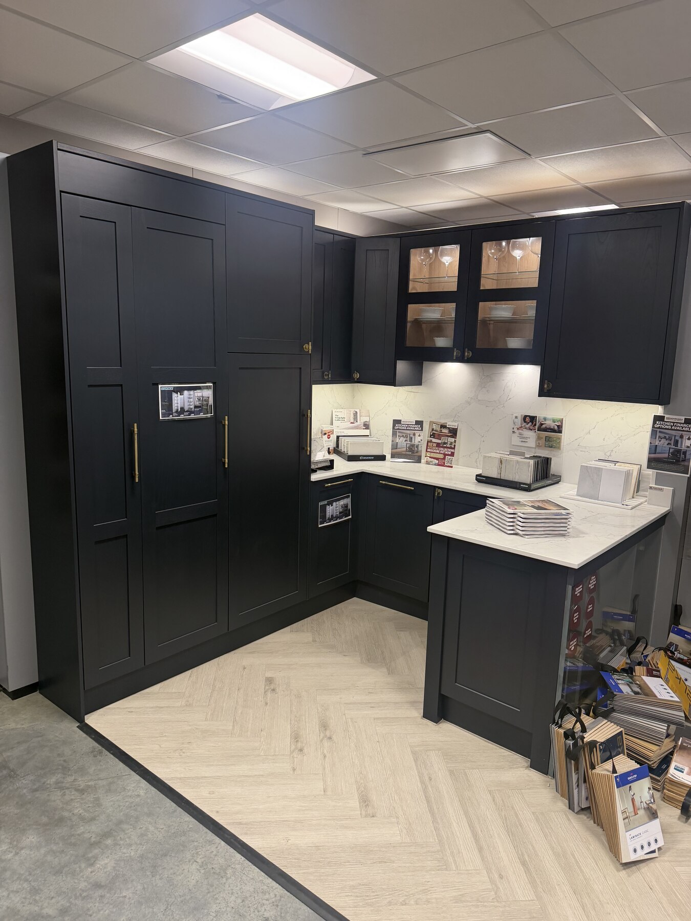 Dark shaker display kitchen with brass handles in a Benchmarx showroom