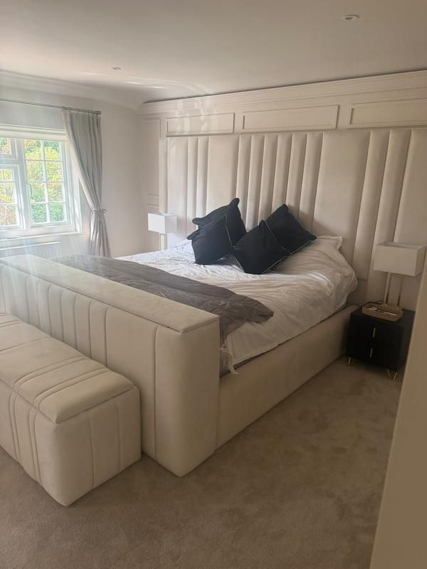Panelled bedroom with a window beside the headboard