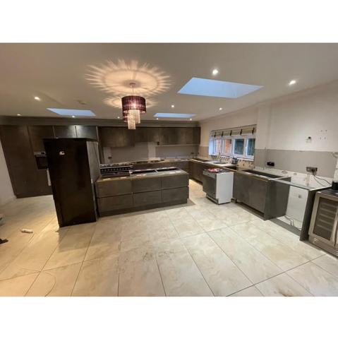 Large concrete-effect kitchen with an island under a skylight