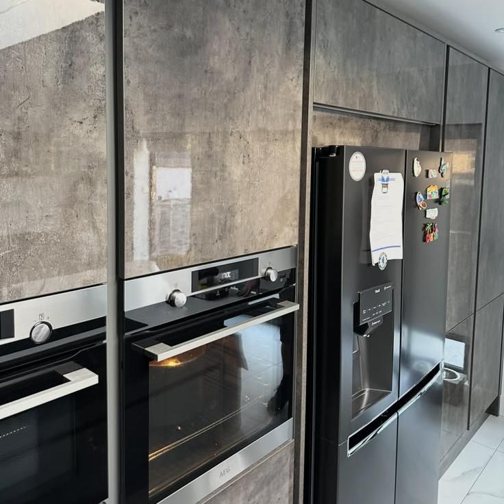 Built-in ovens next to an American-style fridge freezer
