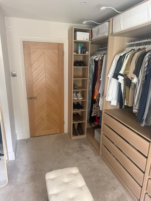 Fitted wardrobe and drawers next to an oak door