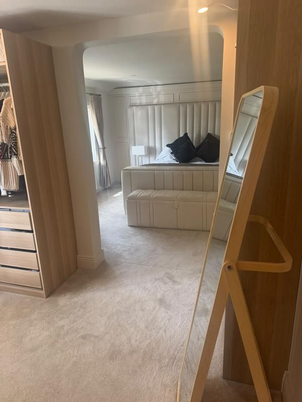 Bedroom seen past the fitted wardrobes