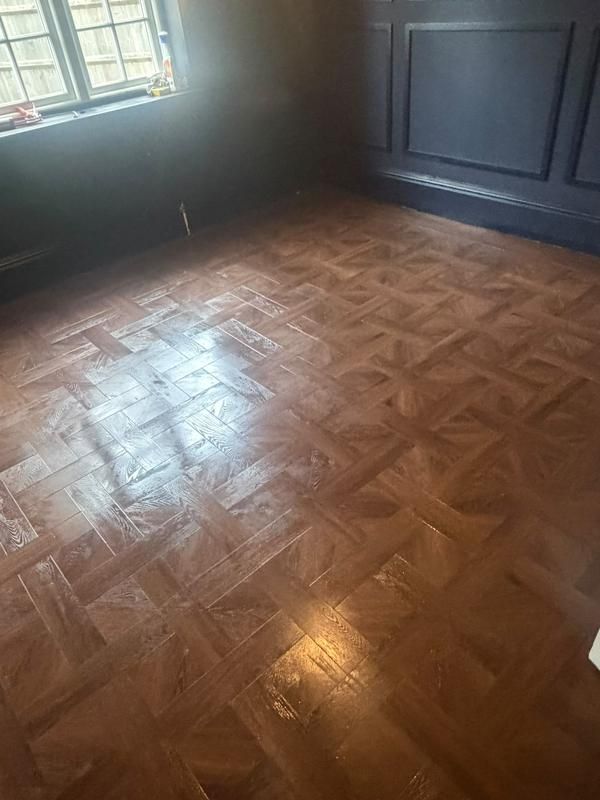 Parquet-style floor and dark panelled walls in natural light