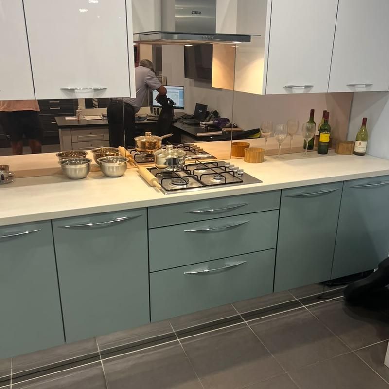 Sage green kitchen with a gas hob and stainless extractor