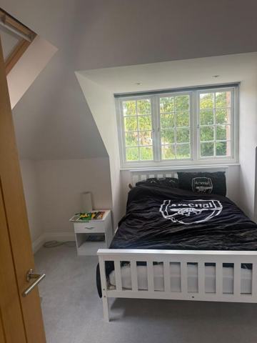 Bedroom with a sloped ceiling, dormer window and grey carpet