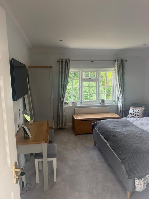 Bedroom with a desk and wall-mounted TV