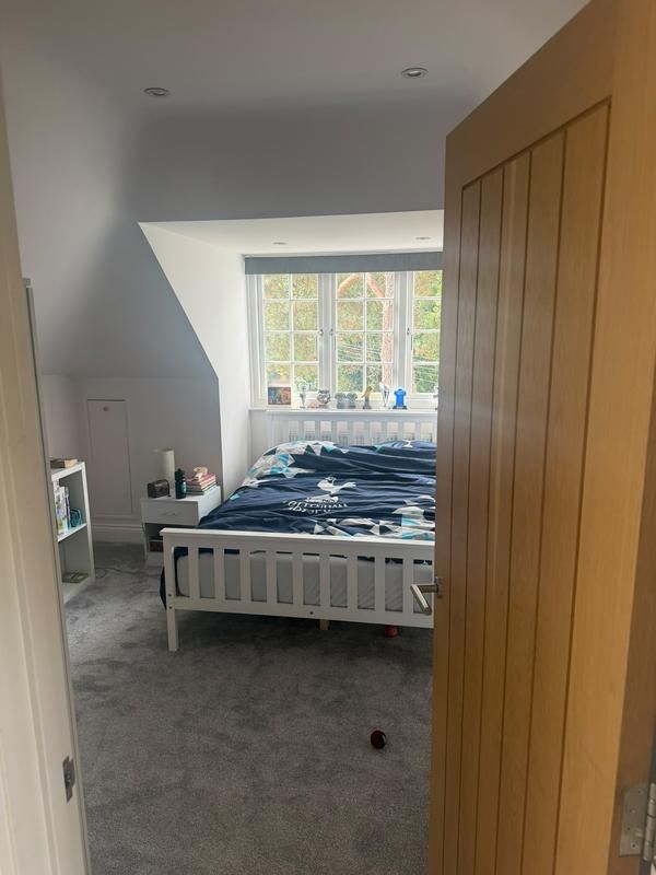 Bedroom seen through an open oak door
